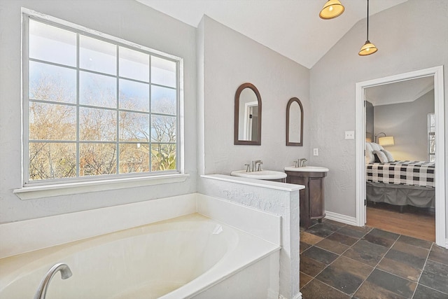 bathroom with a tub to relax in and lofted ceiling