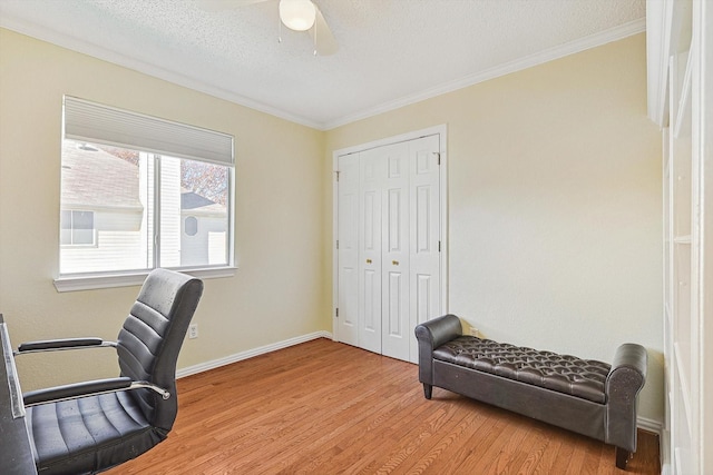 office space featuring ceiling fan, crown molding, light hardwood / wood-style flooring, and a textured ceiling