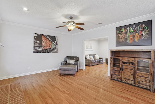 sitting room featuring crown molding, hardwood / wood-style floors, ceiling fan, and a textured ceiling