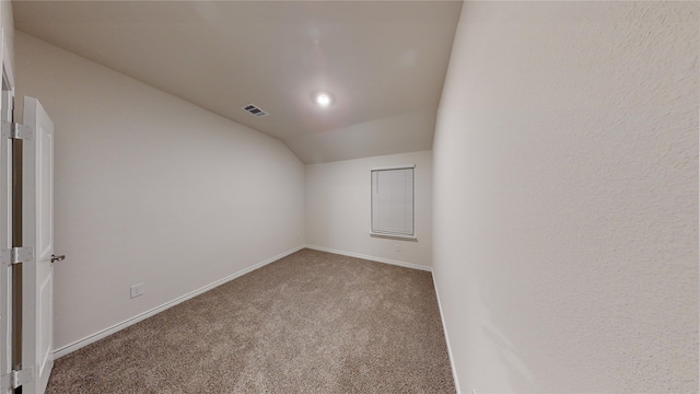 spare room with carpet flooring and vaulted ceiling