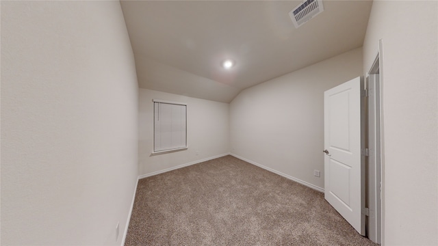 carpeted spare room featuring vaulted ceiling