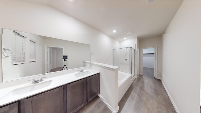 bathroom with wood-type flooring, vanity, and shower with separate bathtub