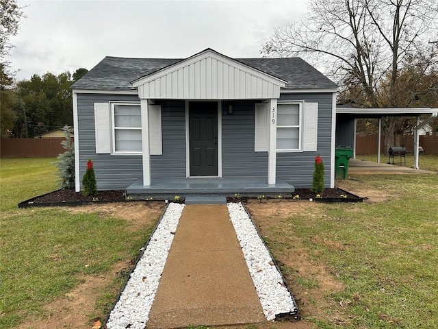 bungalow-style house with a front yard and a carport