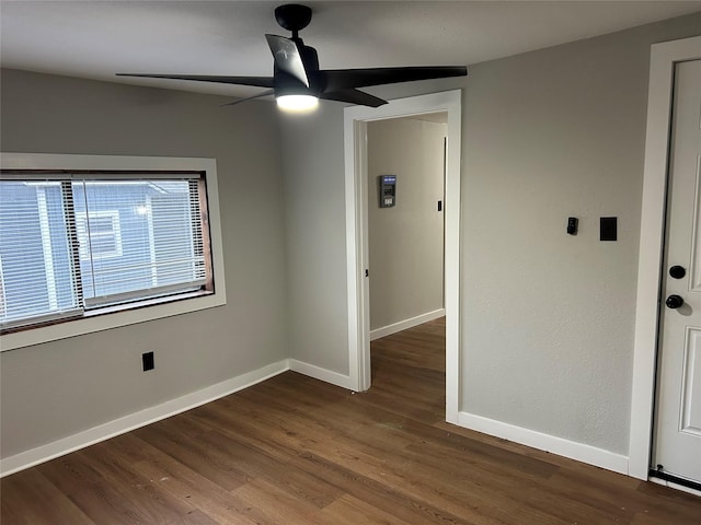 empty room featuring ceiling fan and dark wood-type flooring