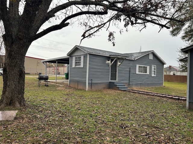 rear view of property featuring a lawn