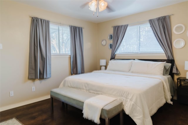 bedroom featuring ceiling fan, dark wood-type flooring, and multiple windows