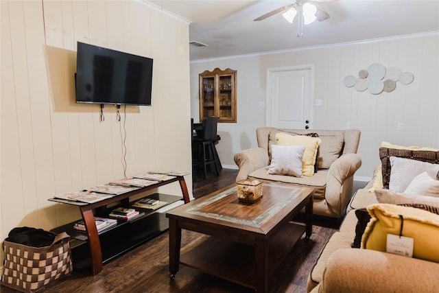 living room featuring wood walls, dark wood-type flooring, and ornamental molding