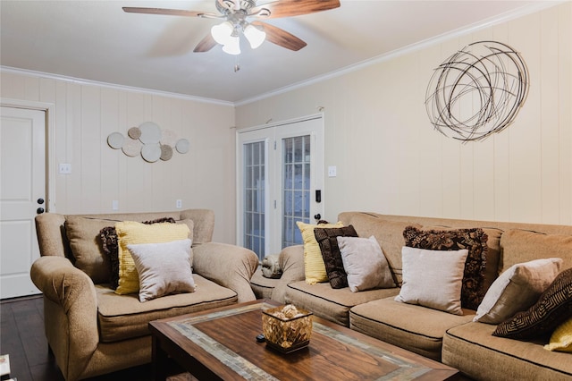 living room featuring wood-type flooring, french doors, wooden walls, ornamental molding, and ceiling fan