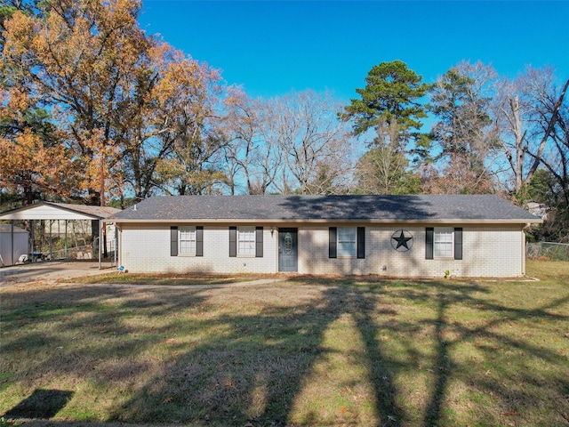 ranch-style home featuring a carport and a front yard