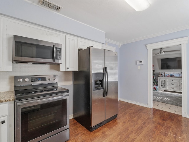 kitchen with white cabinetry, appliances with stainless steel finishes, dark hardwood / wood-style flooring, and ornamental molding