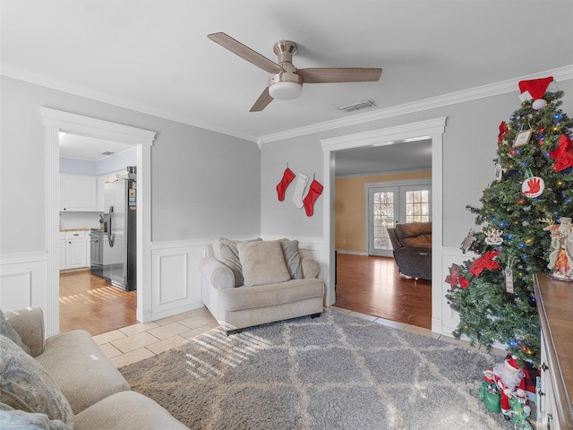 living room with ceiling fan, ornamental molding, french doors, and light tile patterned flooring