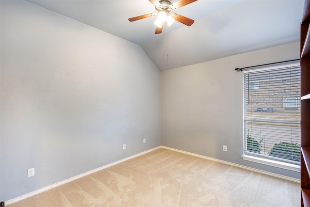 carpeted spare room featuring ceiling fan and lofted ceiling