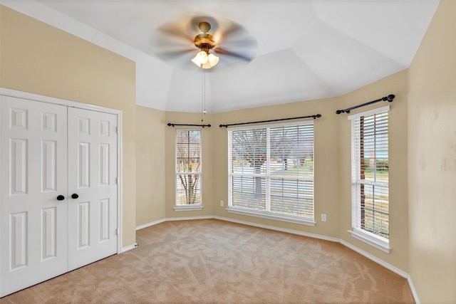 carpeted empty room with ceiling fan and lofted ceiling