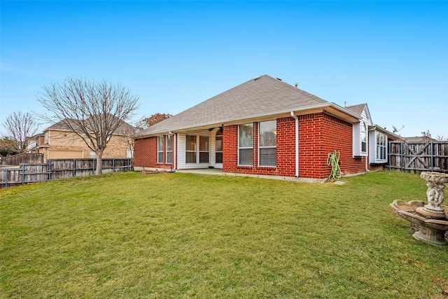 back of property with a patio area, ceiling fan, and a lawn