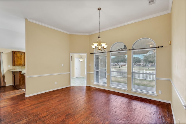 unfurnished dining area featuring hardwood / wood-style flooring, ornamental molding, and a chandelier