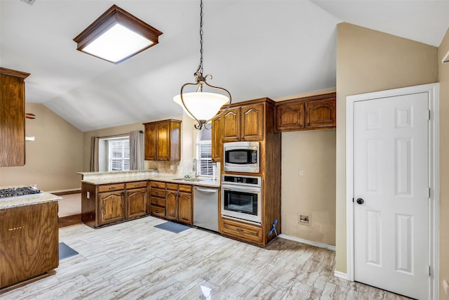 kitchen with sink, vaulted ceiling, kitchen peninsula, pendant lighting, and stainless steel appliances