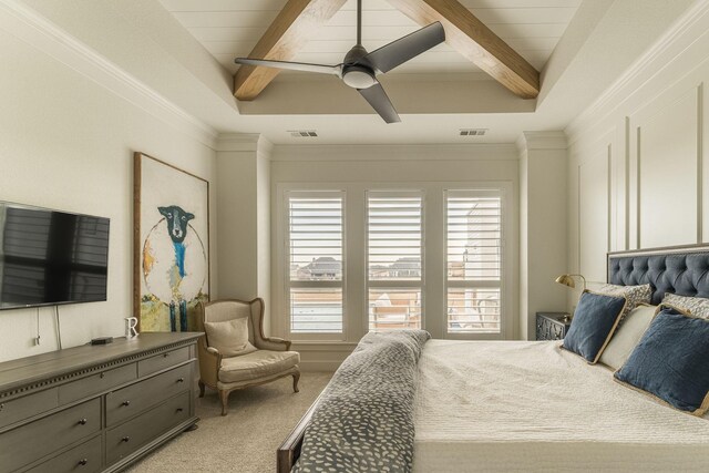 bedroom with multiple windows, light colored carpet, a tray ceiling, and ceiling fan