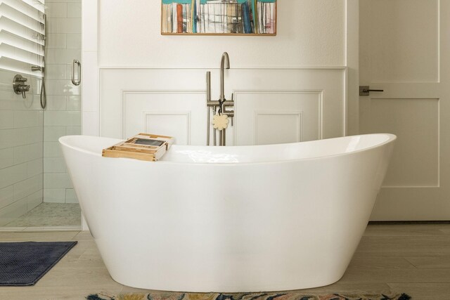 bathroom featuring vanity, wood-type flooring, crown molding, and plus walk in shower