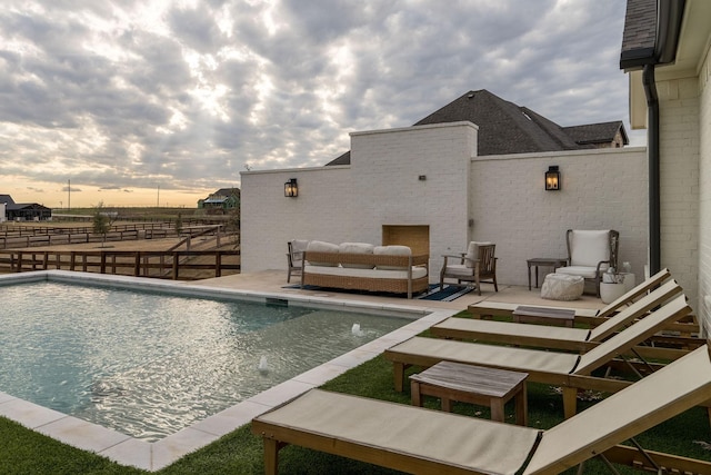 view of swimming pool featuring a fenced in pool, outdoor lounge area, a patio, and fence