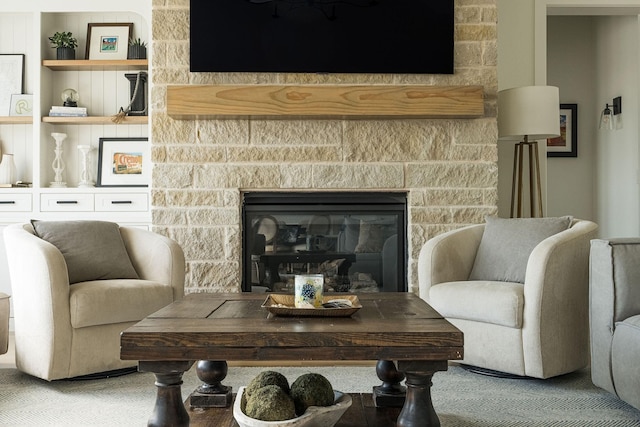 living room with a stone fireplace