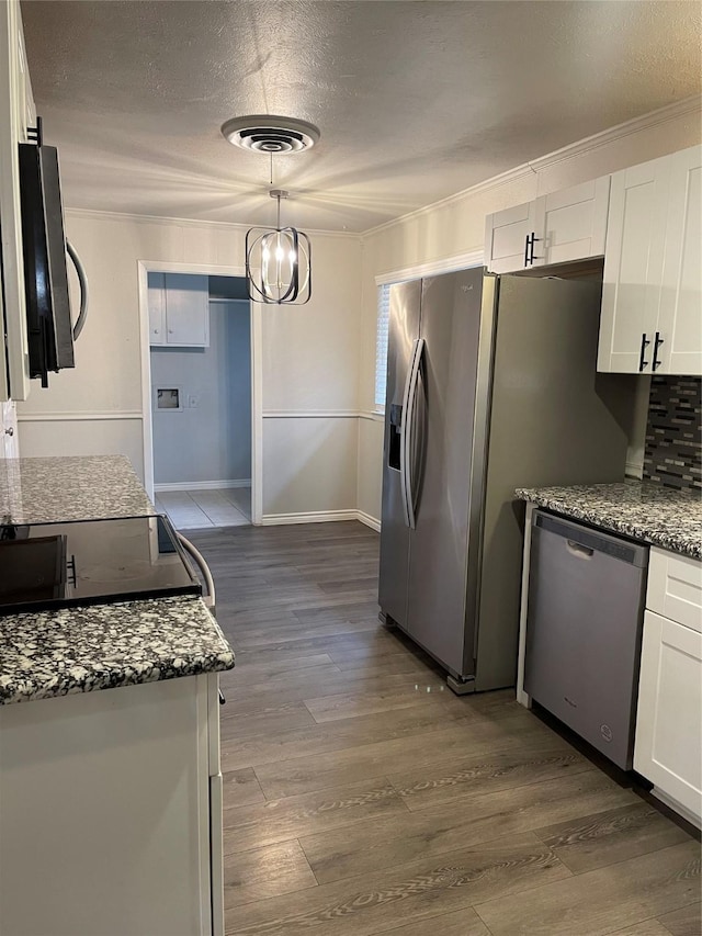 kitchen with stainless steel appliances, dark stone countertops, white cabinetry, and sink