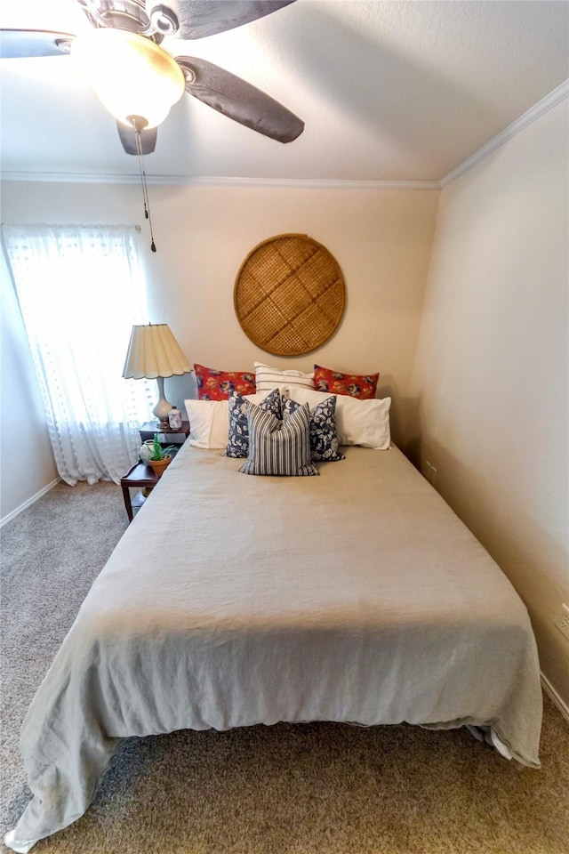 bedroom with ceiling fan, crown molding, and carpet floors