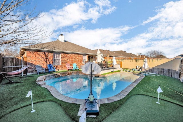 view of pool with a patio area and a lawn