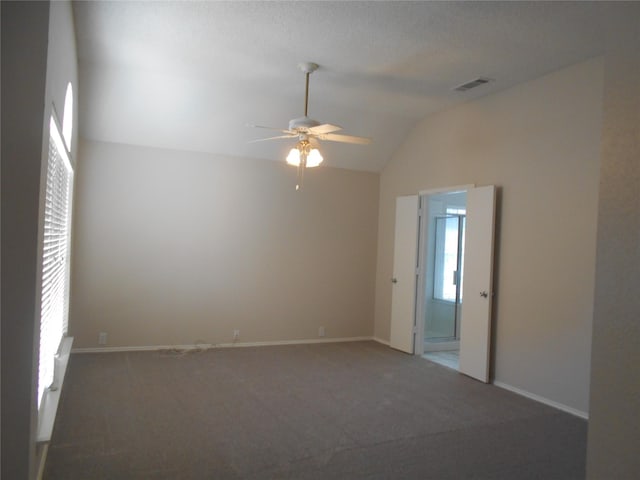 unfurnished room featuring ceiling fan, carpet flooring, lofted ceiling, and plenty of natural light