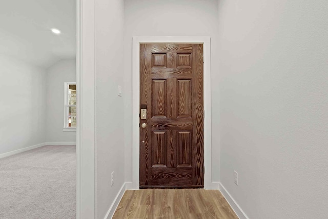 entryway featuring light colored carpet and lofted ceiling