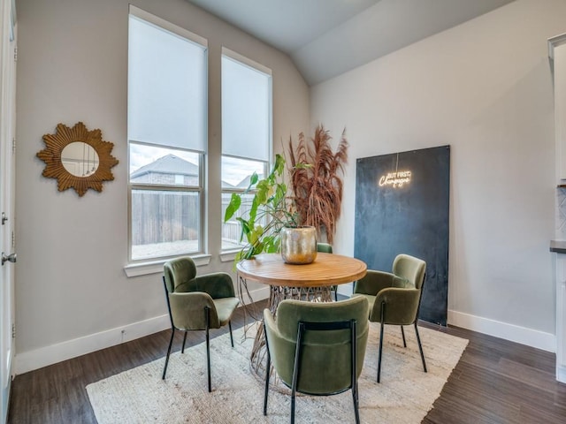 dining space with dark hardwood / wood-style floors and vaulted ceiling