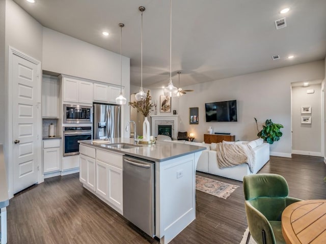 kitchen featuring white cabinets, sink, an island with sink, and stainless steel appliances