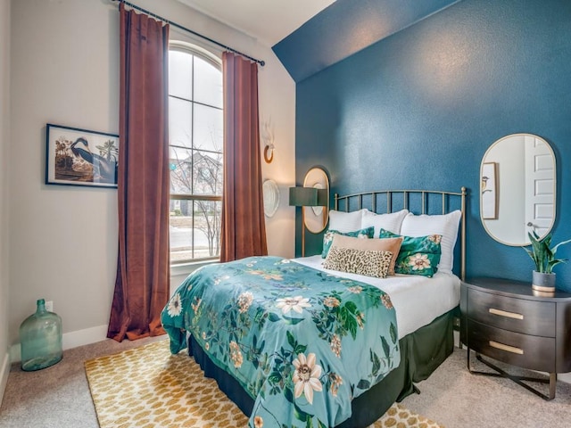 carpeted bedroom featuring vaulted ceiling and multiple windows