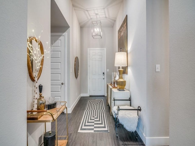 foyer with lofted ceiling, dark hardwood / wood-style floors, and a chandelier