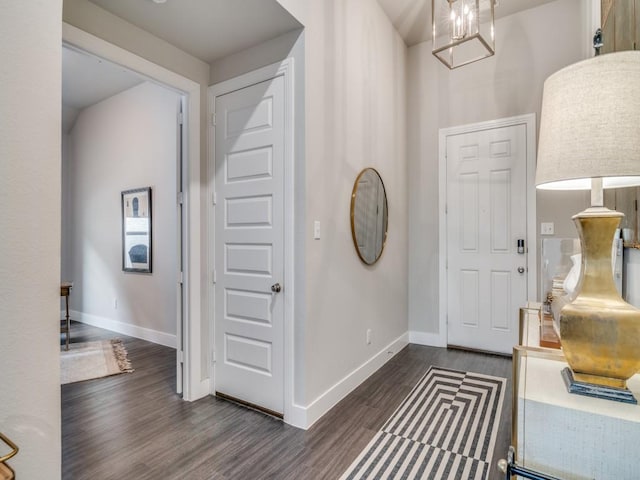 foyer featuring dark wood-type flooring and a notable chandelier