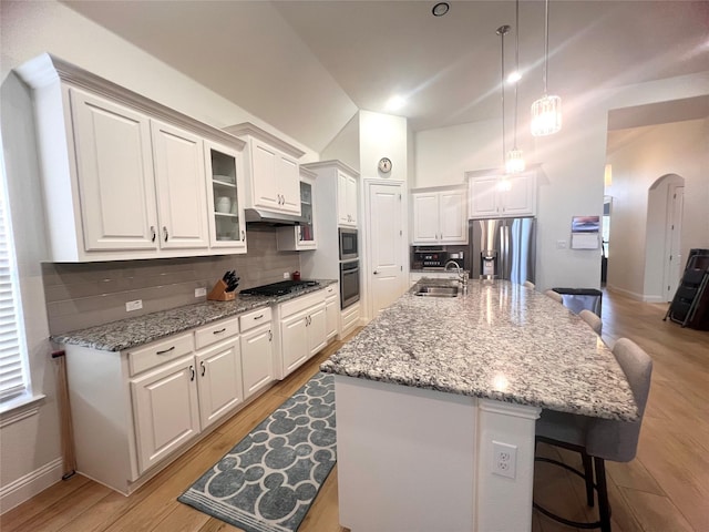 kitchen with a center island with sink, sink, white cabinetry, a kitchen breakfast bar, and stainless steel appliances