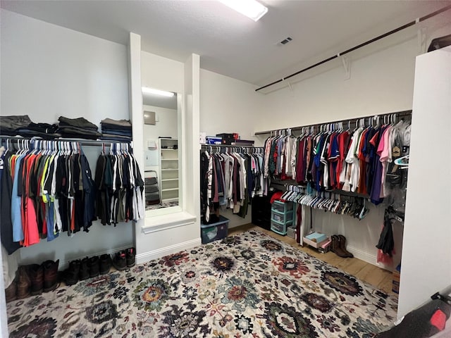 walk in closet with hardwood / wood-style flooring