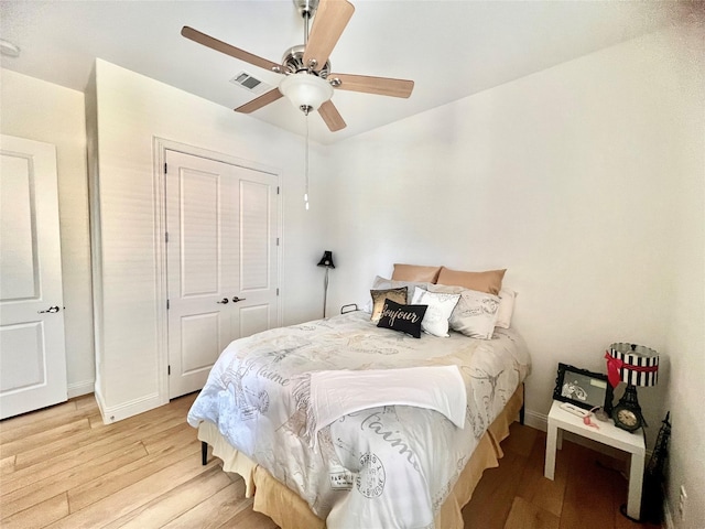 bedroom featuring ceiling fan, a closet, and light wood-type flooring