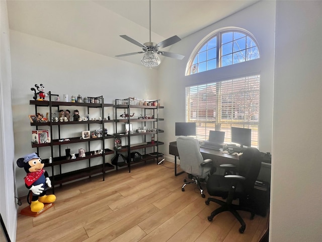 home office with ceiling fan, light wood-type flooring, and lofted ceiling