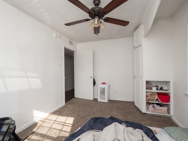 carpeted bedroom featuring ceiling fan and a textured ceiling