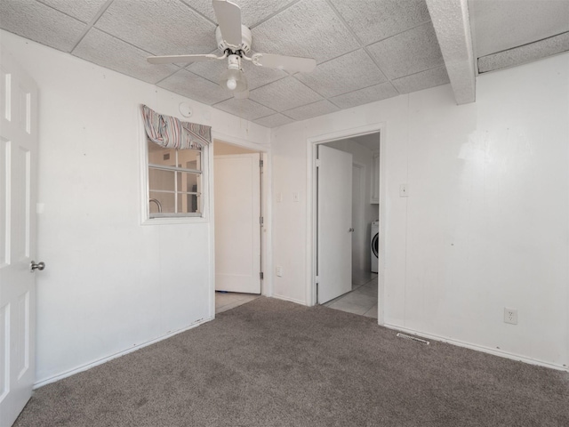 carpeted empty room with ceiling fan and beam ceiling