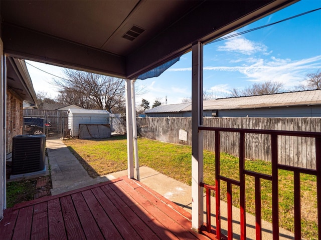 wooden deck with a lawn, central AC, and a storage unit