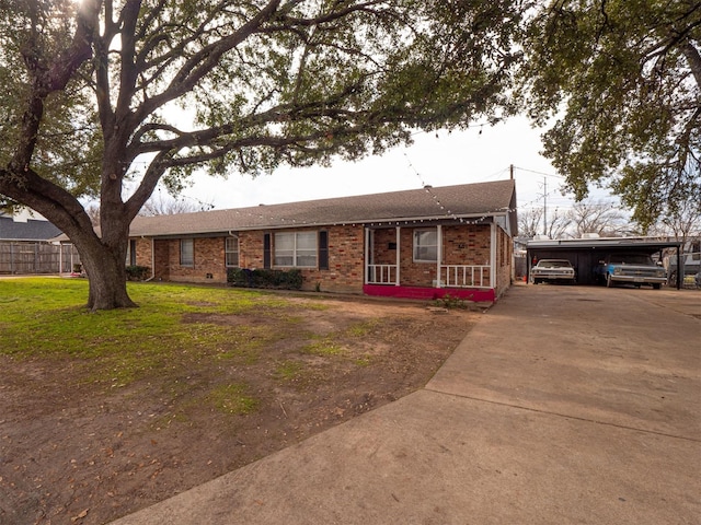 ranch-style home with a front lawn, a carport, and covered porch