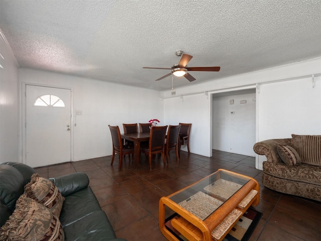 living room with a textured ceiling and ceiling fan