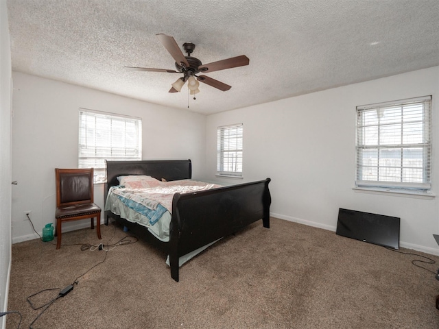 carpeted bedroom featuring ceiling fan and a textured ceiling