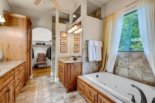 bathroom featuring a bathing tub, tile patterned floors, vanity, and ceiling fan