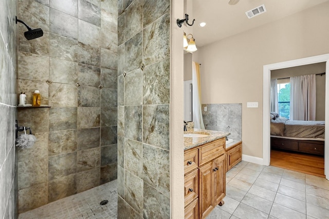 bathroom featuring vanity, tile patterned floors, and tiled shower