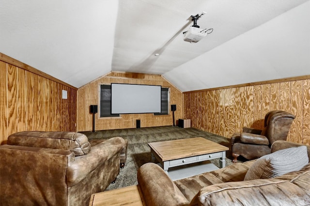 carpeted home theater with lofted ceiling and wooden walls