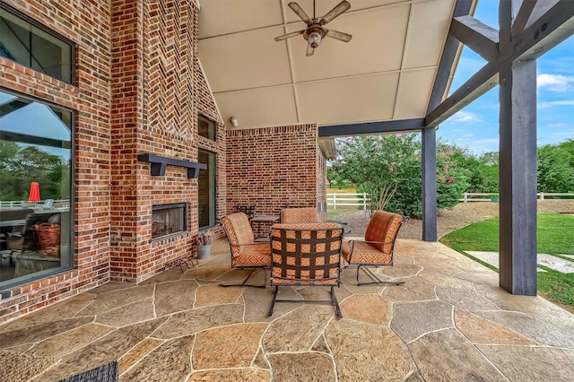 view of patio / terrace with an outdoor brick fireplace and ceiling fan