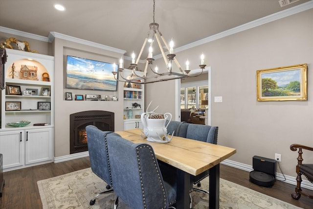 dining area with dark hardwood / wood-style floors, built in features, ornamental molding, and a notable chandelier