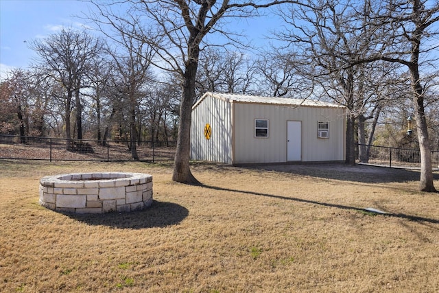 view of outdoor structure featuring an outdoor fire pit and a lawn